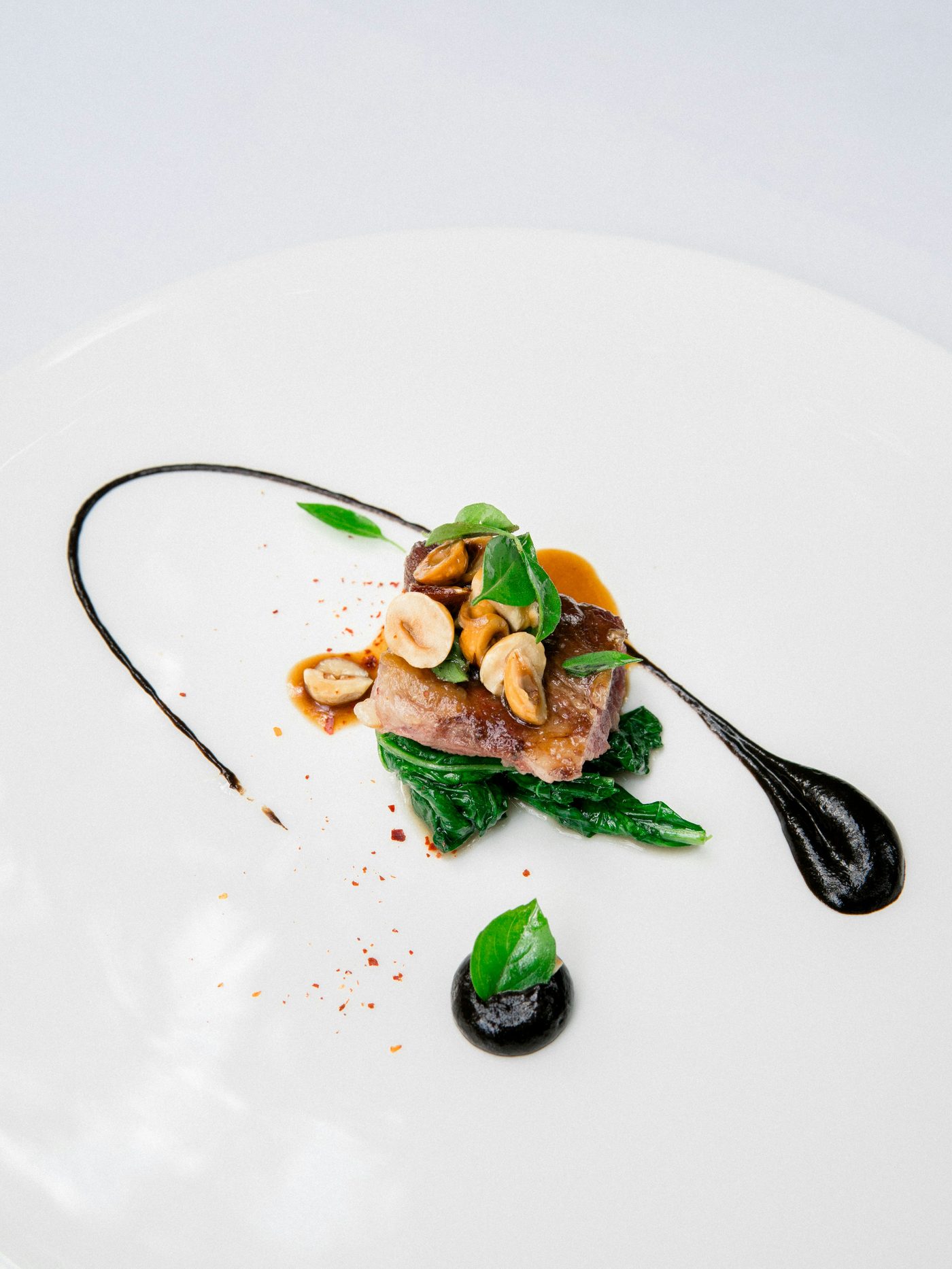 A white plate with fish and vegetables from the Noir House kitchen