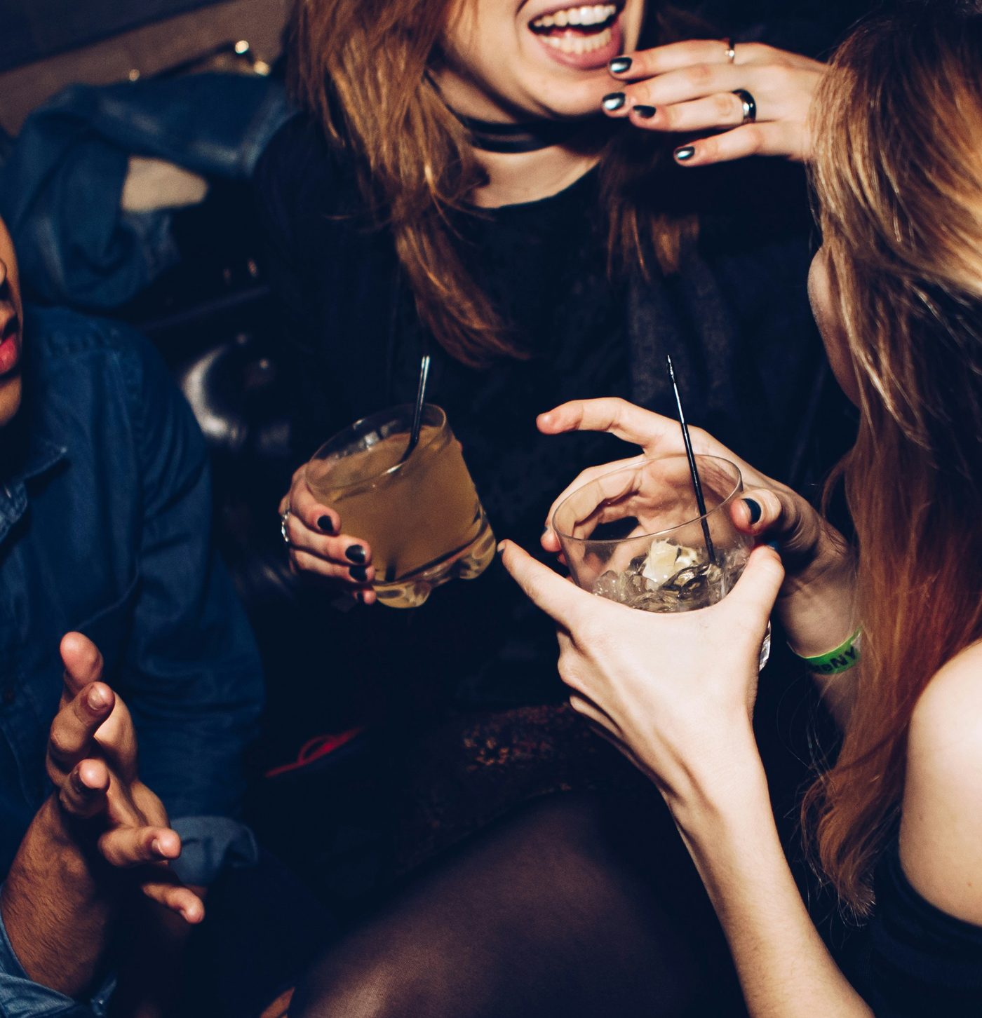 Two guests in conversation, drinks in hand, at Noir House